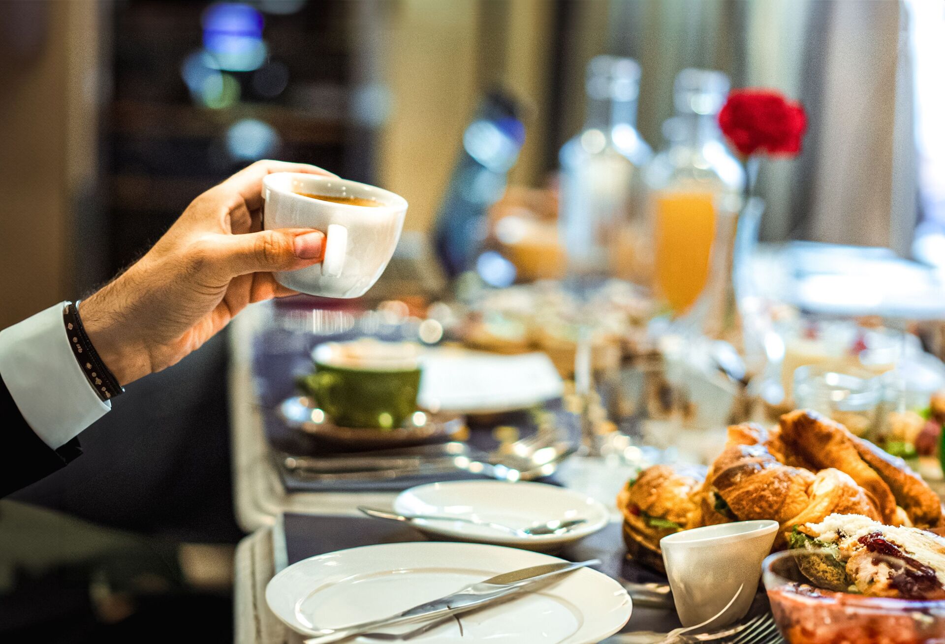 a person holding a cup during a breakfast for hotels